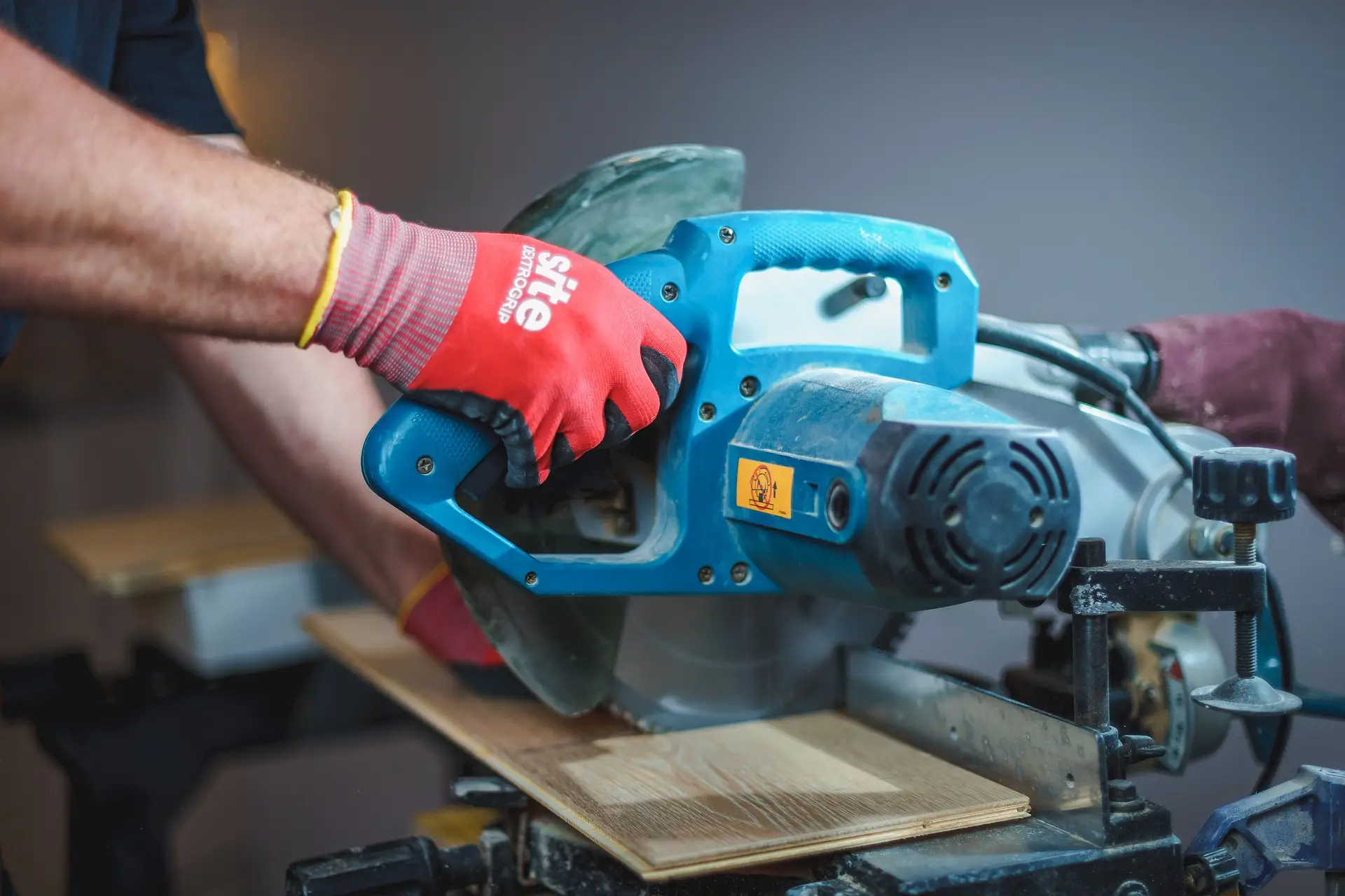 Carpenter working withpower saw.