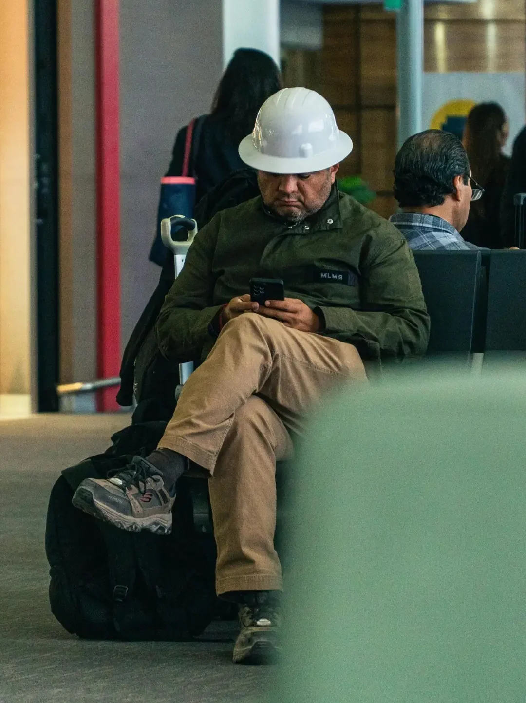 Contractor sitting checking his messages on phone.