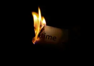 Image of a burning piece of paper with the word "Time" written on it.