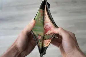 Wallet being held open, showing cash.